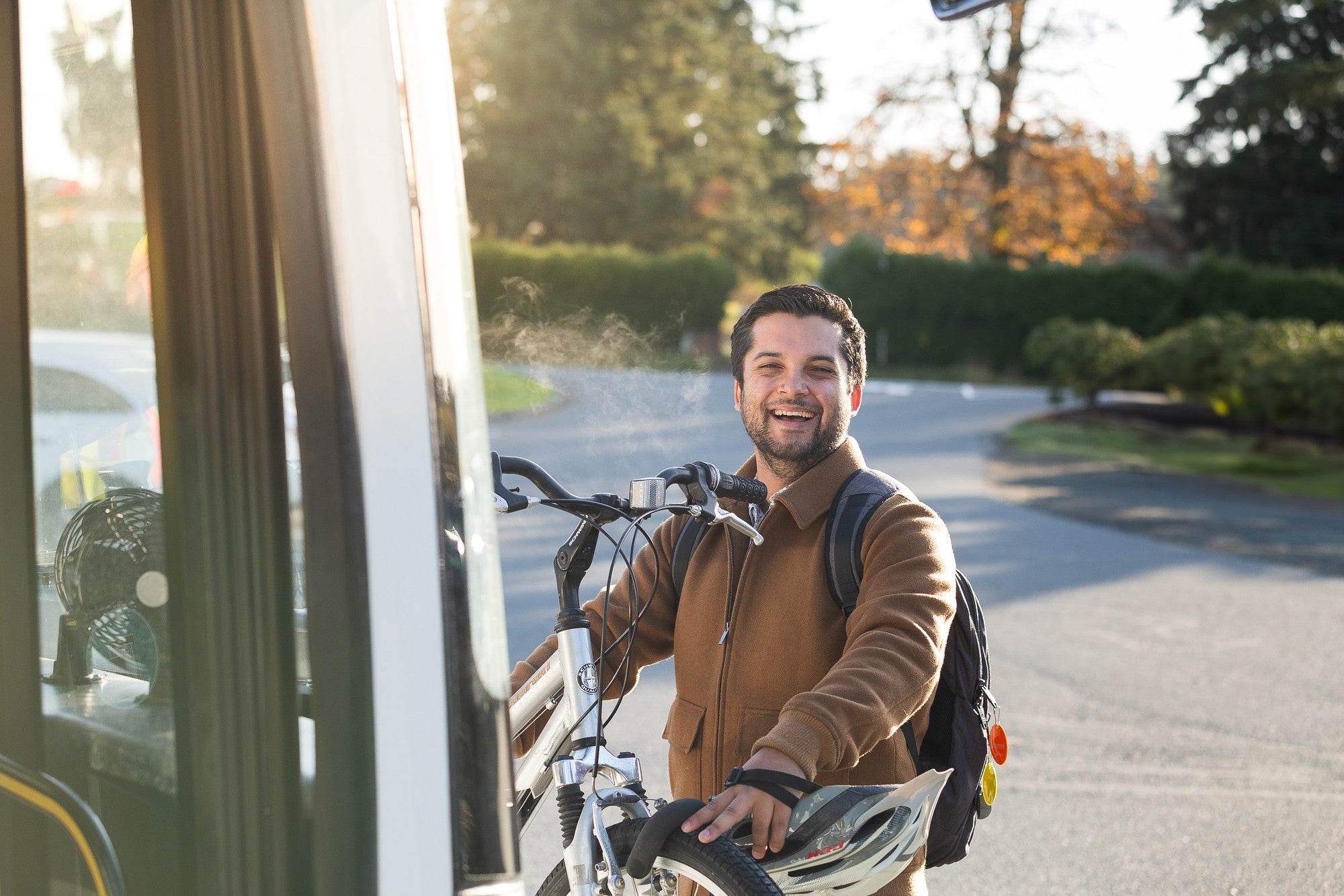 A man placing his bike on the front bike rack of a bus.