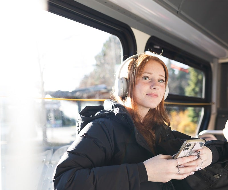 A young woman smiling on a bus.