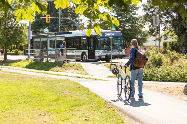 Rider with a bicycle loading onto a transit bus.