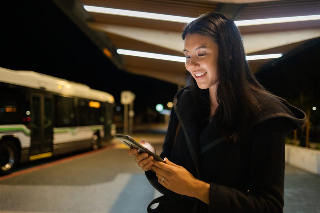 Person looking at her phone app for an update on the bus