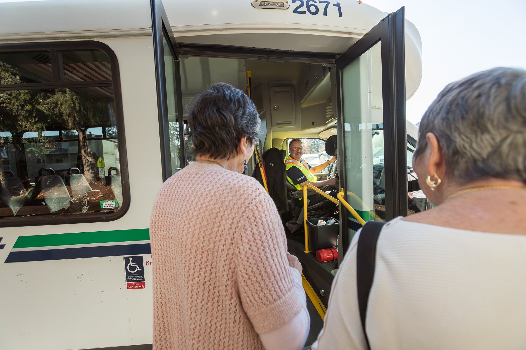 Senior people entering a handyDART bus with ramp deployed.