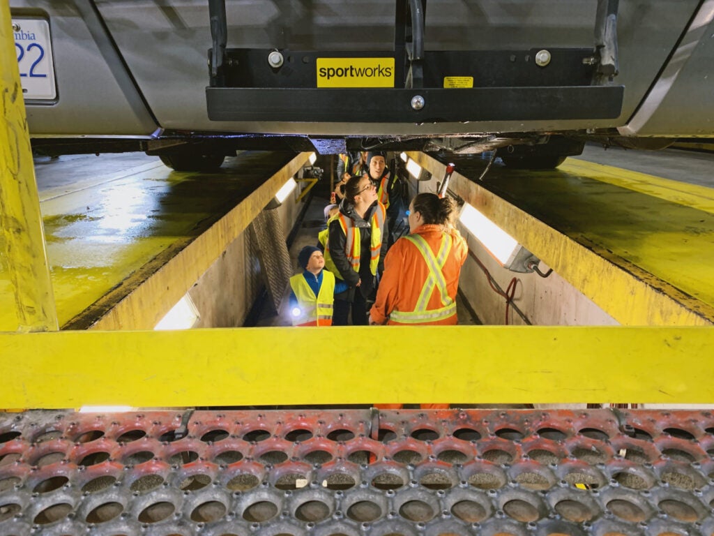 BC Transit Kids Tour look under the bus in the mechanic bay.