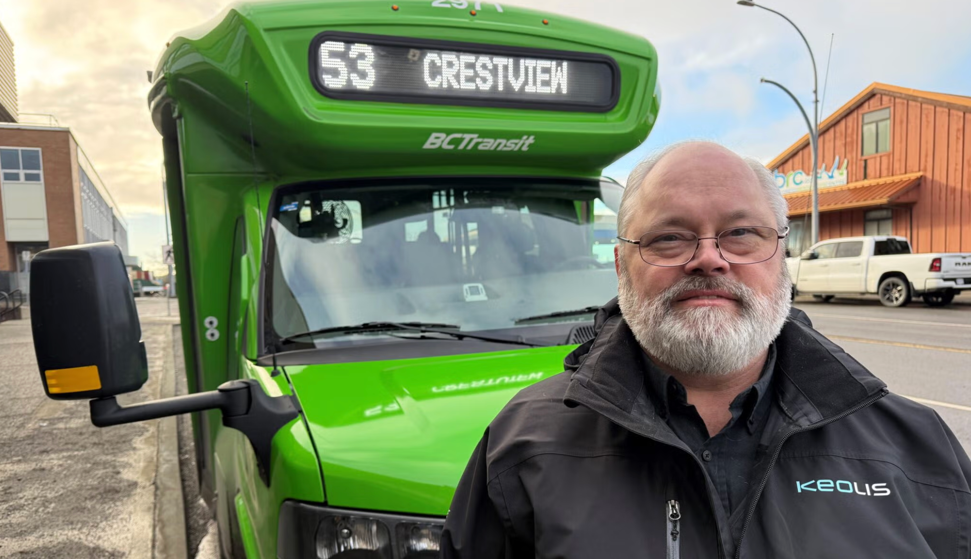 image of older man with white beard in front of a green bc transit bus.