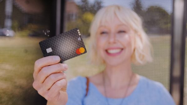 Woman holding credit card so she can pay for bus by tapping her card