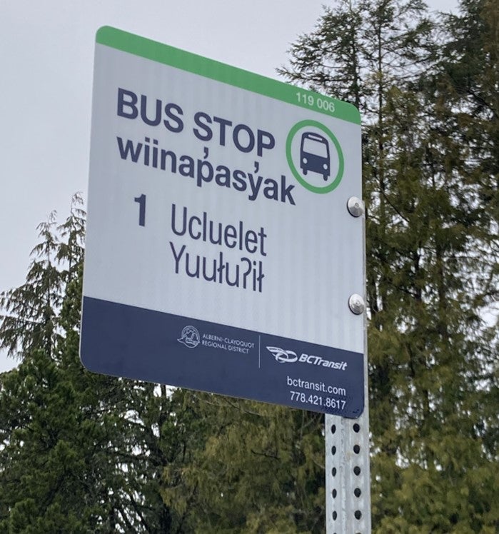 BC Transit bus stop sign that reads: Bus Stop, wiinapasyak, 1, Ucluelet, Yuulu?il.